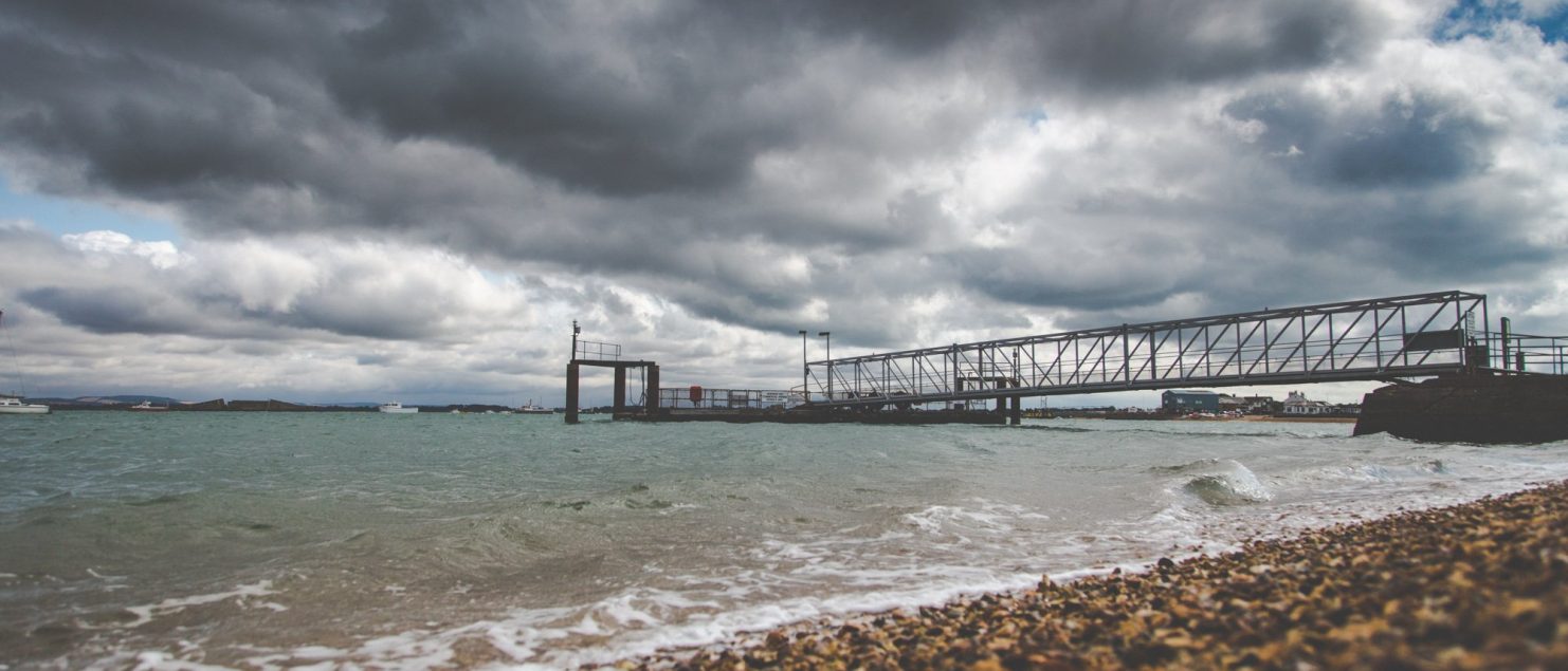 View of the Hayling Ferry from the Eastney Beach, with a rising tide and a cloudy sky