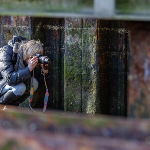 Photographer looking for compositions around a rusty quayside