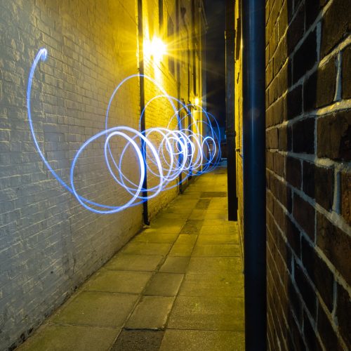 Swirling painted light twists down an alley way in old Portsmouth